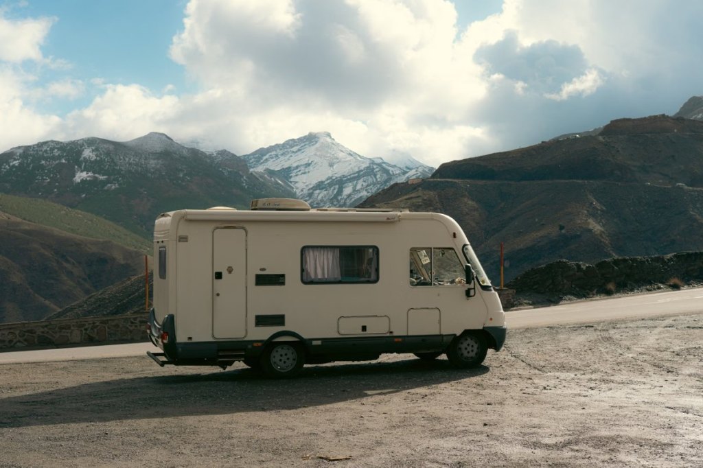 Autocaravana aparcada frente a montañas nevadas en invierno