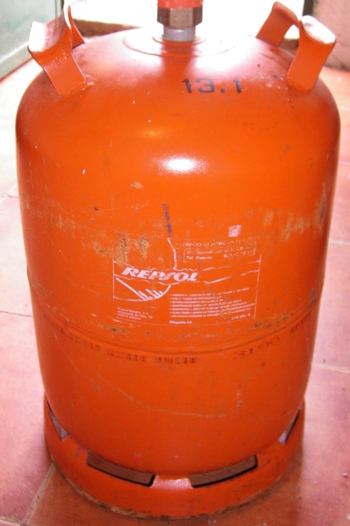 Bombona naranja de butano de 12,5 kg de Repsol sobre un suelo de baldosas