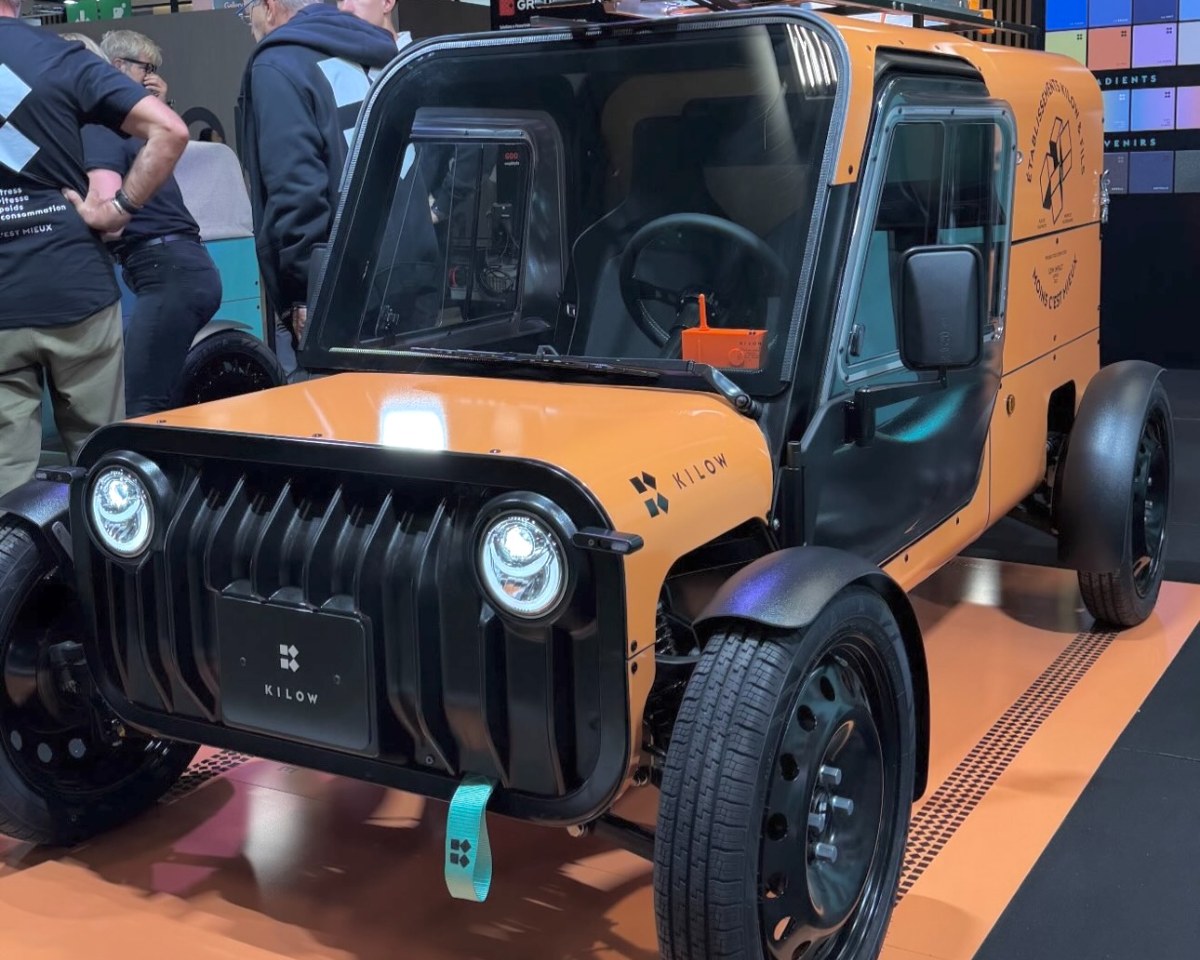 Kilow La Bagnole naranja con caja cerrada en el stand de Kilow del Mondial de l'Auto de París 2026, vista frontal en tres cuartos